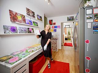 Svetlana in ihrer Wohnung mit Ausstellung ihrer Wildblumen-Fotografie