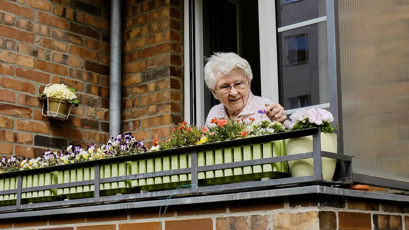 Außenaufnahme: Ältere Frau auf Balkon