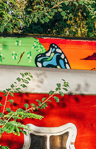 Ein roter Wagen hinter einem Baum halb versteckt