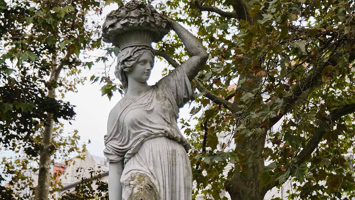 Außenaufnahme: Statue einer Frau, die einen Korb auf dem Kopf trägt