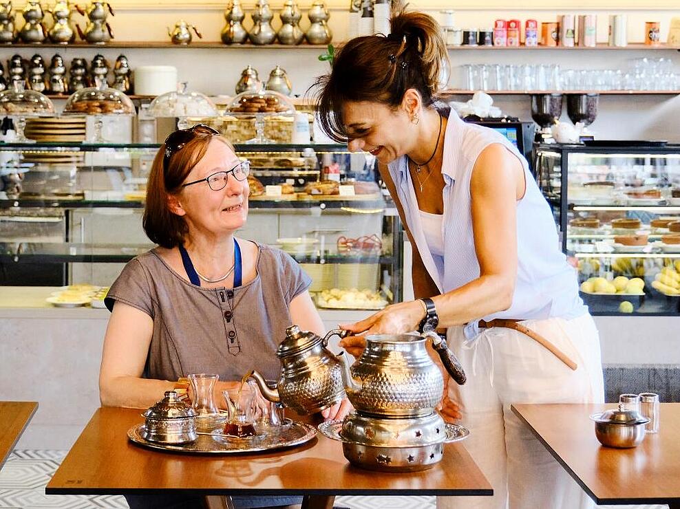 Innenaufnahme: Frau serviert älterer Frau in Café türkischen Tee