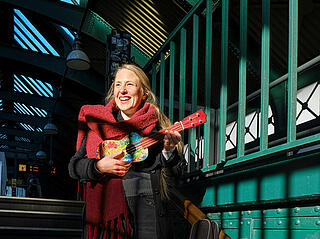 Musikerin Laura Hagnäs spielt Ukulele auf einer U-Bahn-Treppe