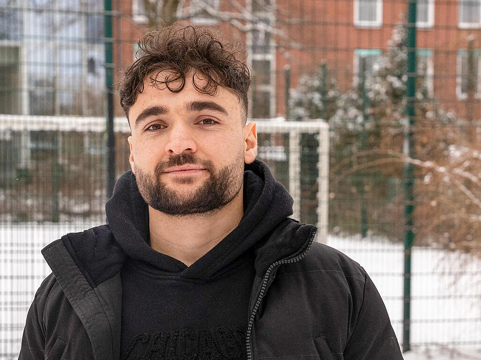 Außenaufnahme: Ein Mann steht vor einer schneedeckten Tischtennisplatte