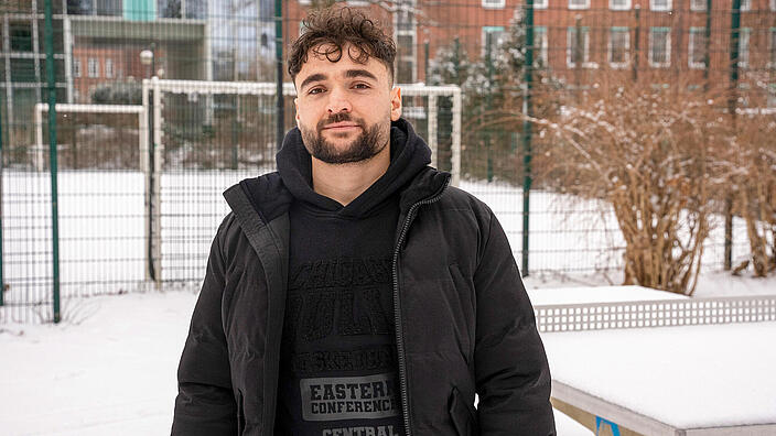 Außenaufnahme: Ein Mann steht vor einer schneedeckten Tischtennisplatte