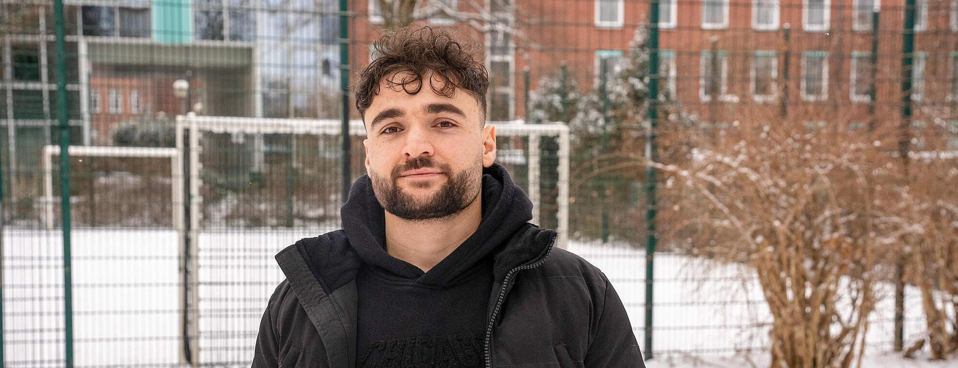 Außenaufnahme: Ein Mann steht vor einer schneedeckten Tischtennisplatte