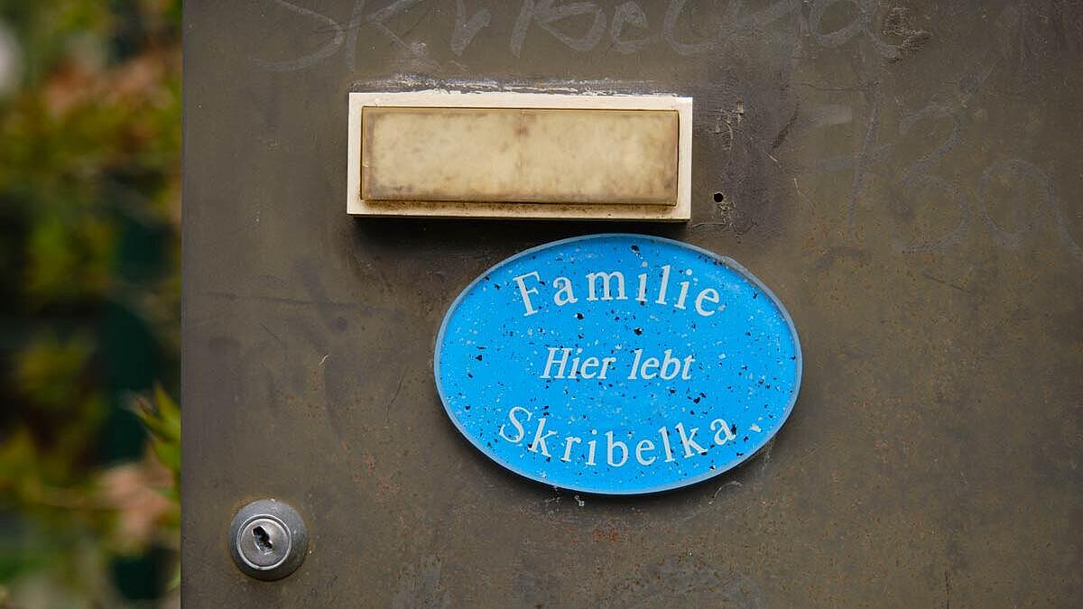 Außenaufnahme: Türschild mit Aufschrift Hier lebt Familie Skribelka