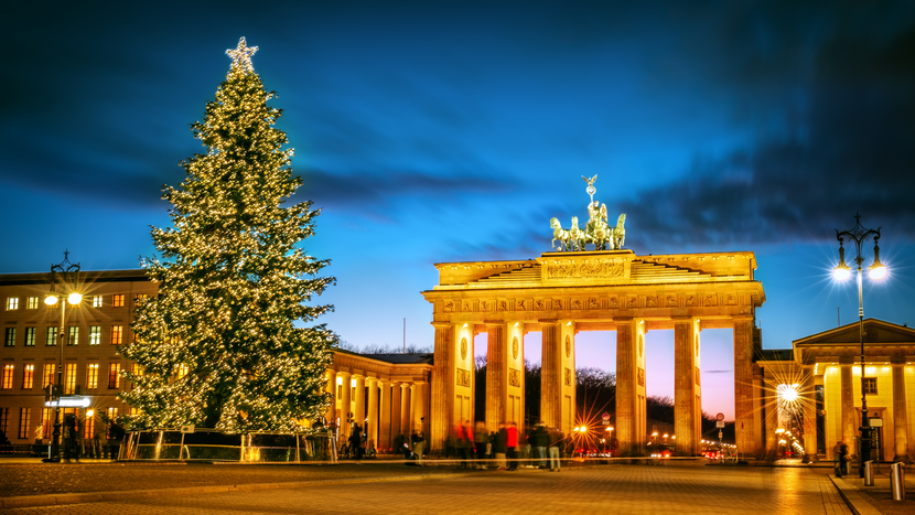 Geschmückter Weihnachtsbaum auf dem Pariser Platz vor dem Brandenburger Tor bei Nacht.